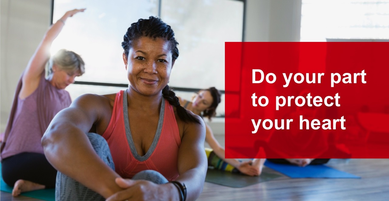 Woman sitting in yoga class in front of other women stretching in the background