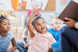 Child raising hand at school