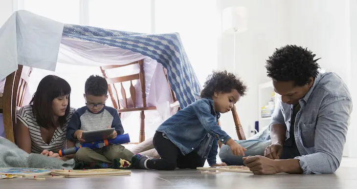 family playing underneath a table tent