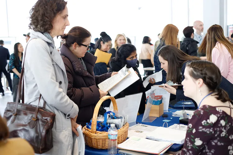 A group of people looking at pieces of paper and talking