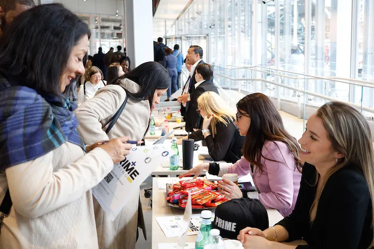 Woman chatting at a table with another woman standing