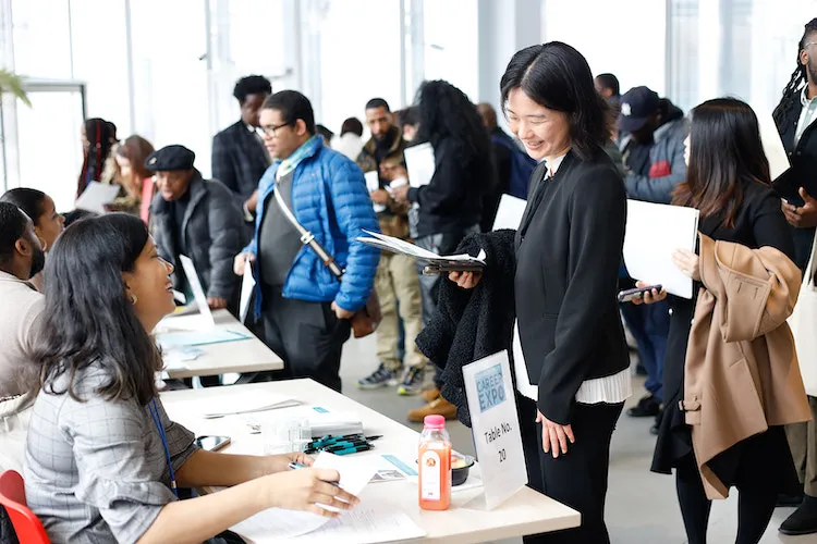 Woman talking by table and smiling with other woman smiling